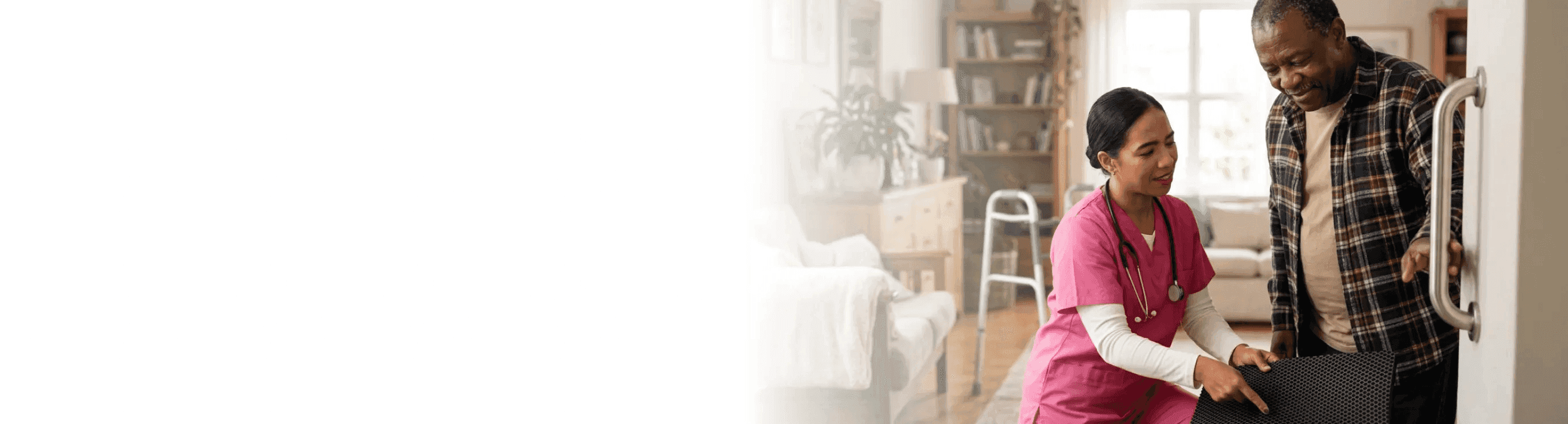 caregiver assisting a senior to safely walk across a room