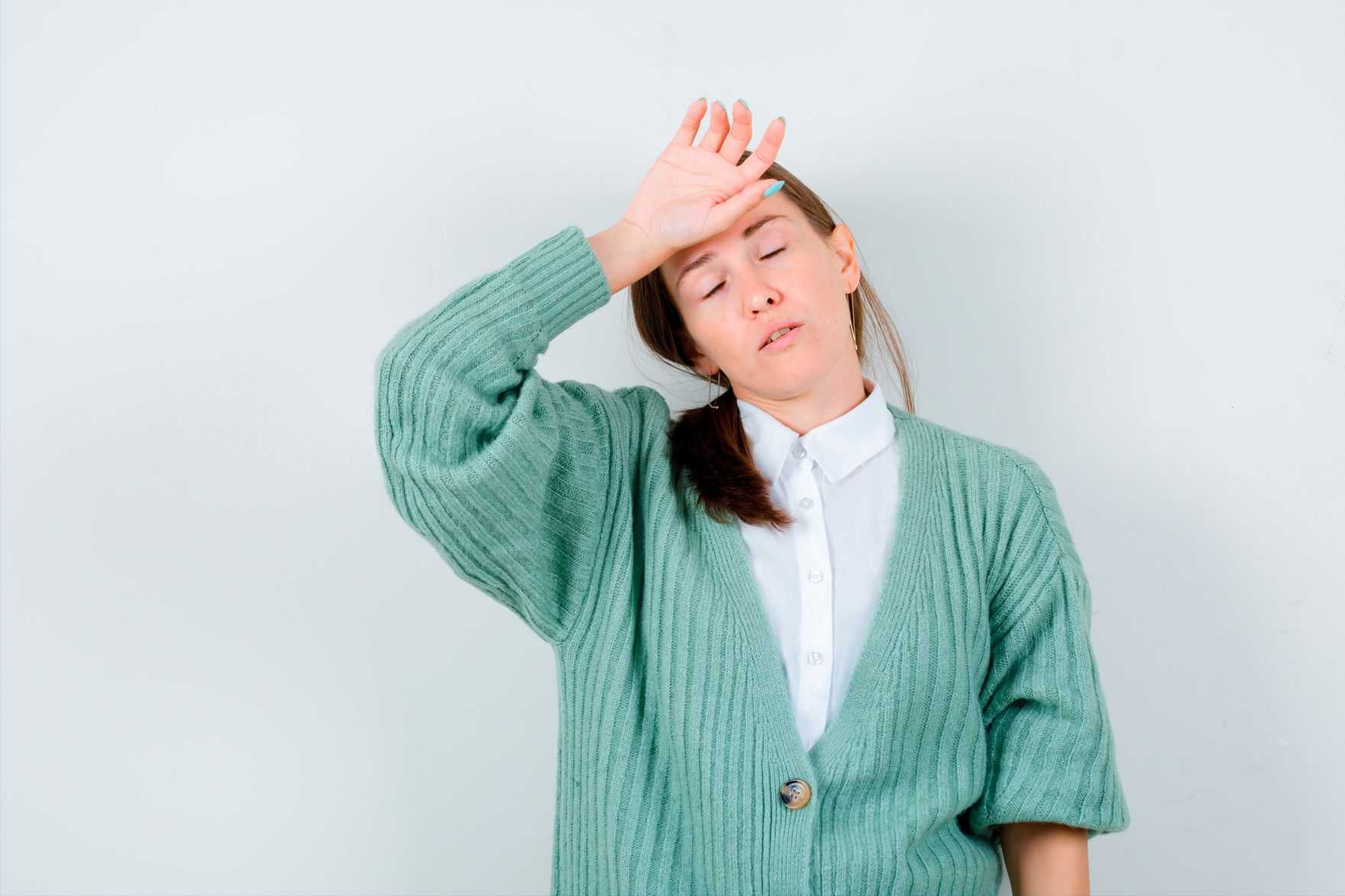 Tired woman resting hand on forehead