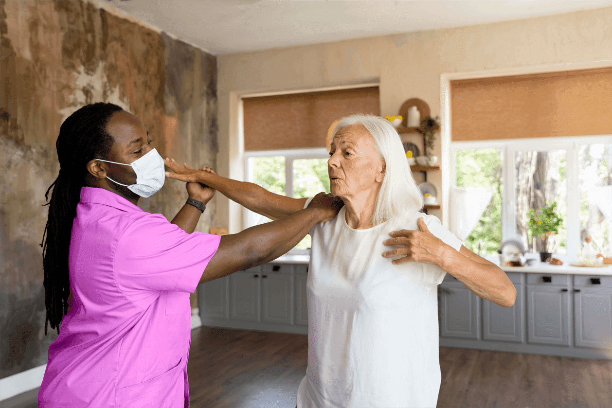 caregiver helping senior lady with exercise