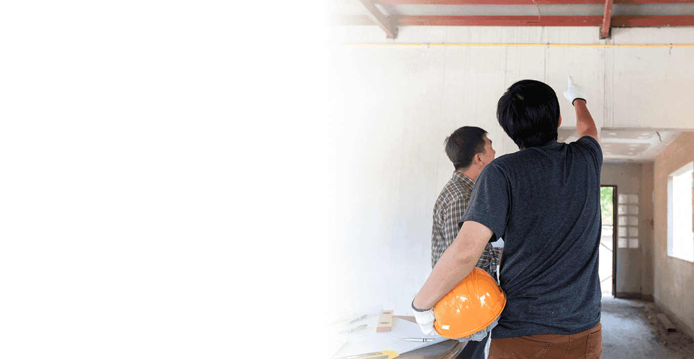 Two men doing construction work inside a home