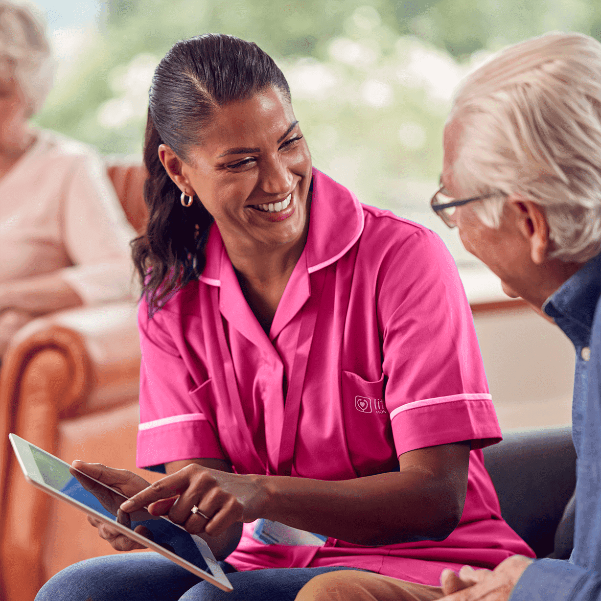 senior man talking to  female nurse care worker using digital tablet