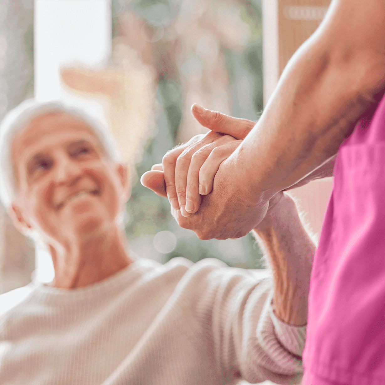 Nurse offering holding elder's hand 