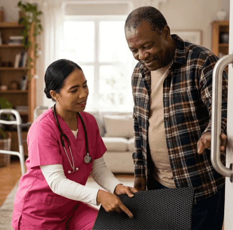 caregiver assisting a senior to safely walk across a room