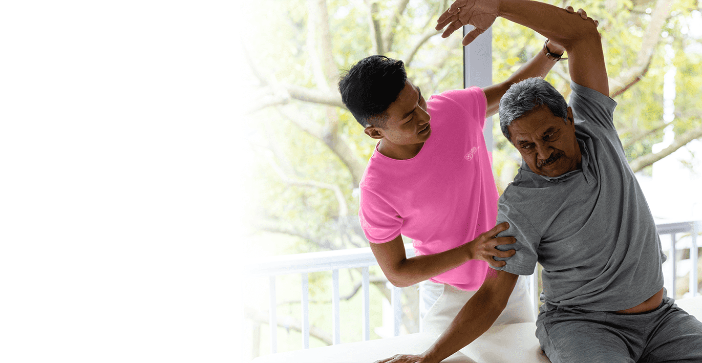 Male physiotherapist advising senior male patient stretching arm