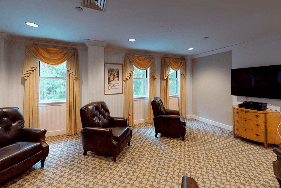 Room with 6 chairs facing a tv