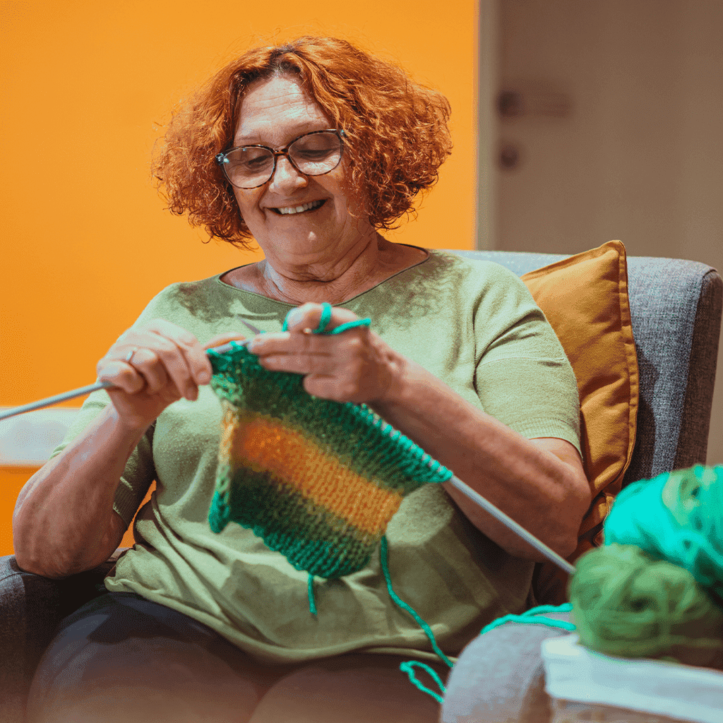 Smiling lady doing crochet