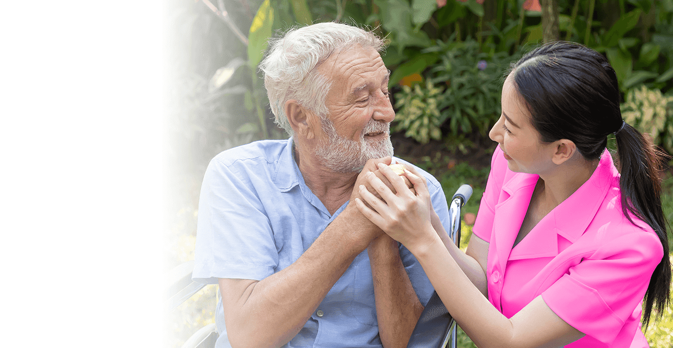 caregiver and senior man holding hands