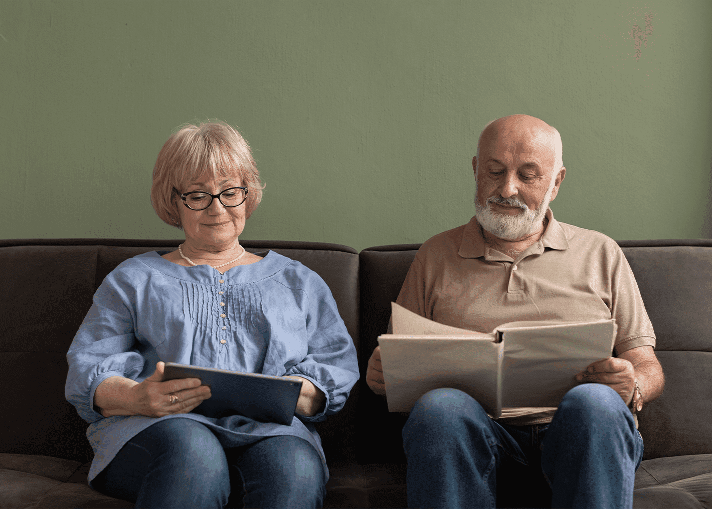 pair of elders reading together in couch