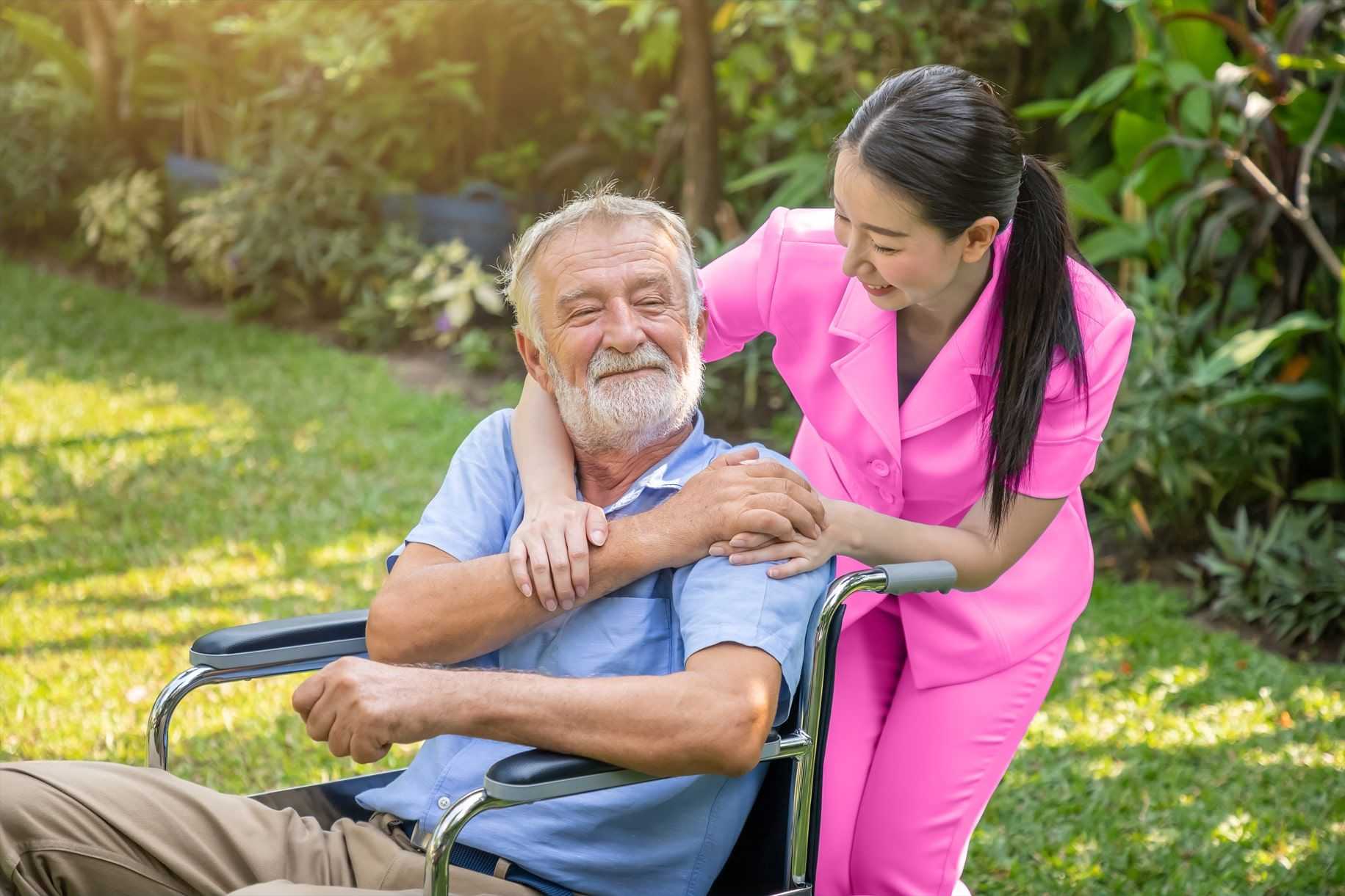 caregiver hugging senior on wheelchair