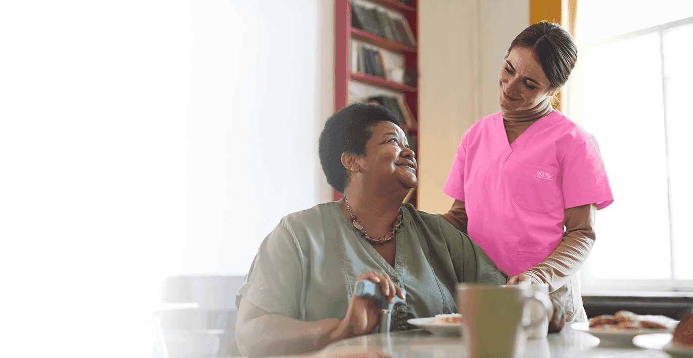 nurse and senior lady looking at eachother smiling