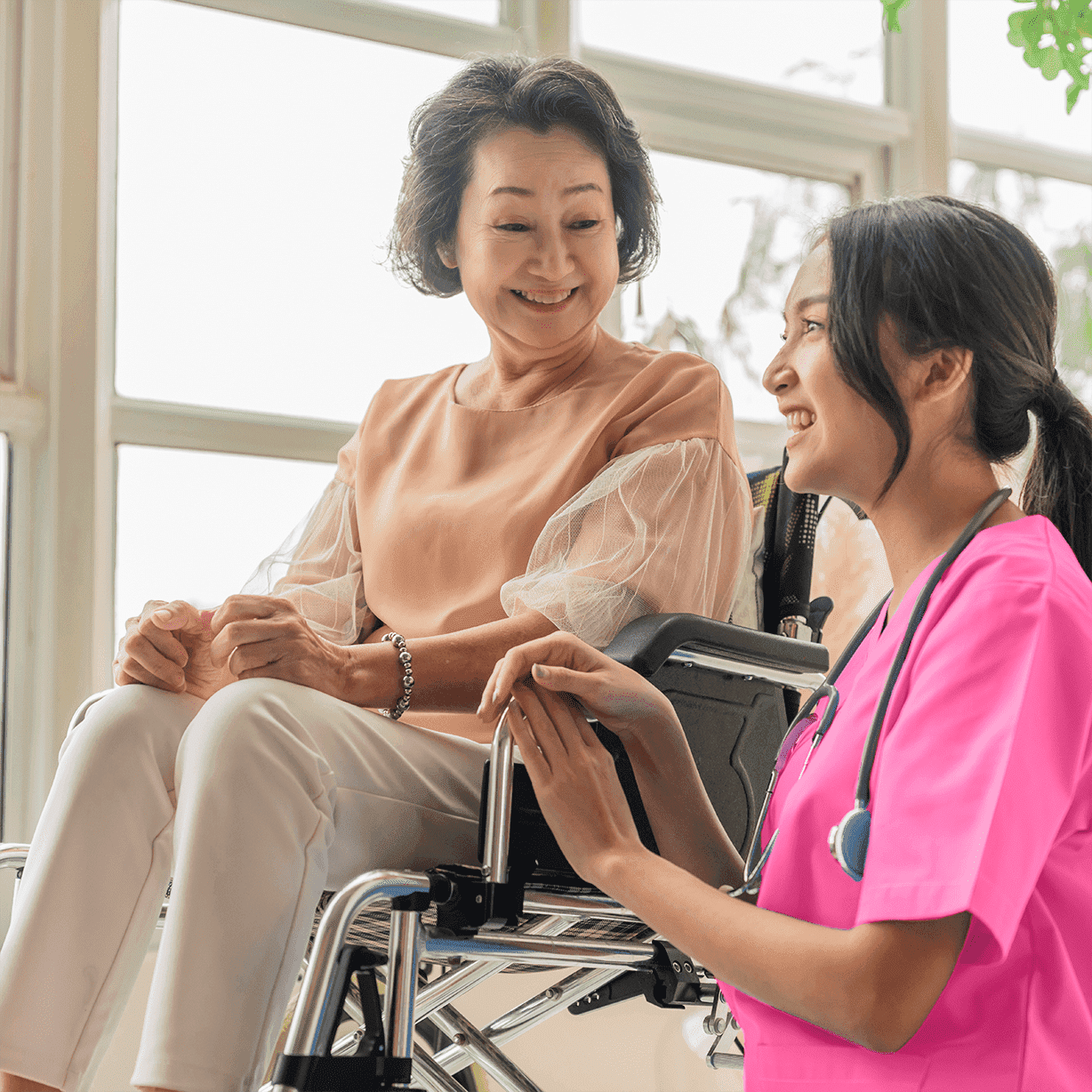 Young asian caregiver caring for elderly patient in wheelchair